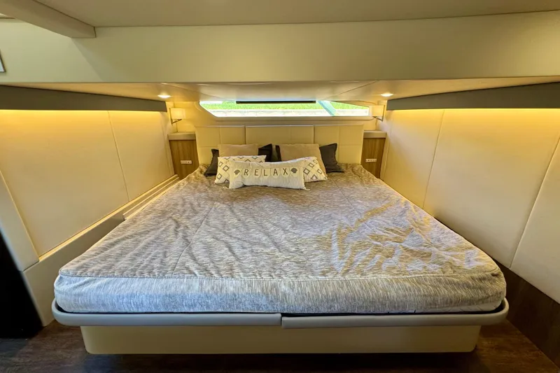 Slide: The Image of Luxurious bedroom interior of 2022 Regal 42 XO yacht with cozy bedding and ambient lighting. - 30