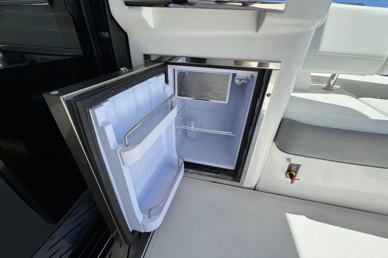 Slide: The Image of Open mini fridge on 2022 Regal 42 XO yacht, showcasing interior storage space. - 8