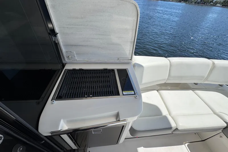 Slide: The Image of Outdoor grill and seating area on 2022 Regal 42 XO yacht by the water. - 9