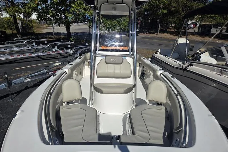 Slide: The Image of 2023 Key West 203 FS boat interior with seating and console, parked outdoors. - 14