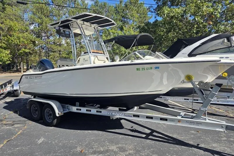 The Image of 2023 Key West 203 FS boat on trailer, parked outdoors with trees in background. - 2