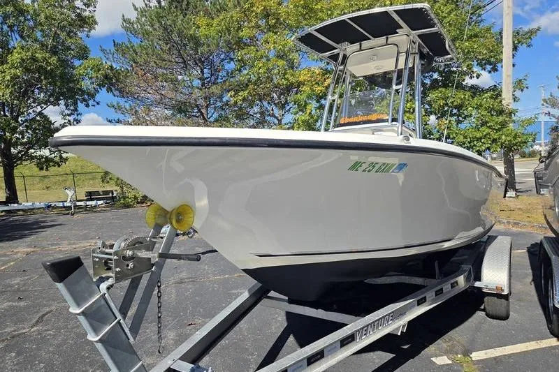 Slide: The Image of 2023 Key West 203 FS boat on trailer, parked outdoors with trees in background. - 8