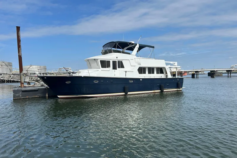 The Image of 2001 Jefferson Pilothouse 57 yacht docked in a marina under a clear blue sky. - 0