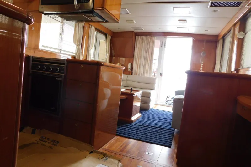 Slide: The Image of Wooden cabinet interior on a 2001 Jefferson Pilothouse 57 yacht, featuring a metal rod and hinge. - 28