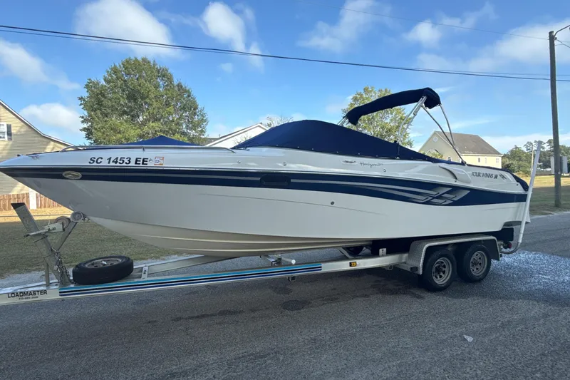 Slide: The Image of 2000 Four Winns 260 Horizon boat on trailer, parked on a residential street. - 2