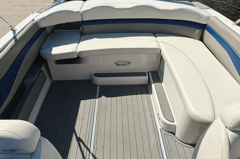 Slide: The Image of 2000 Four Winns 260 Horizon boat interior with white and blue seating, gray flooring. - 22