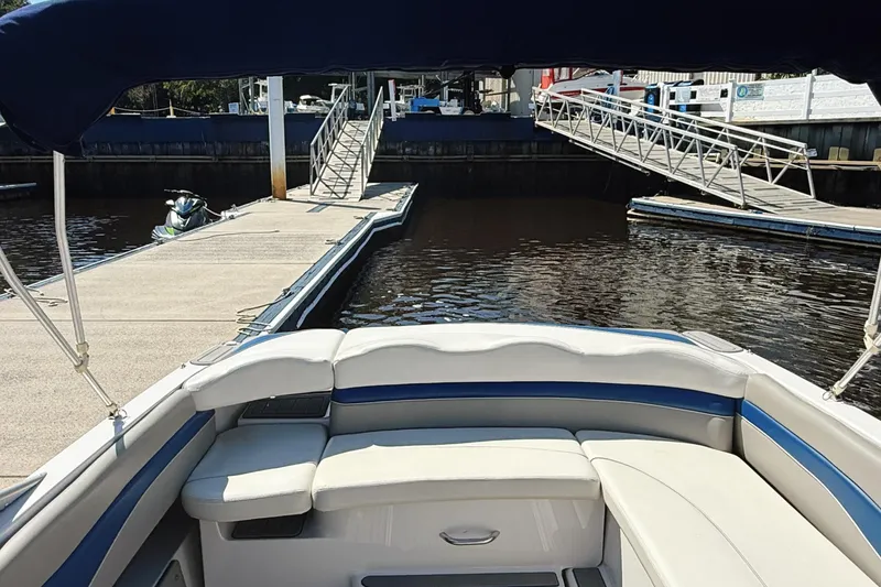 Slide: The Image of 2000 Four Winns 260 Horizon boat docked at marina with seating area. - 23