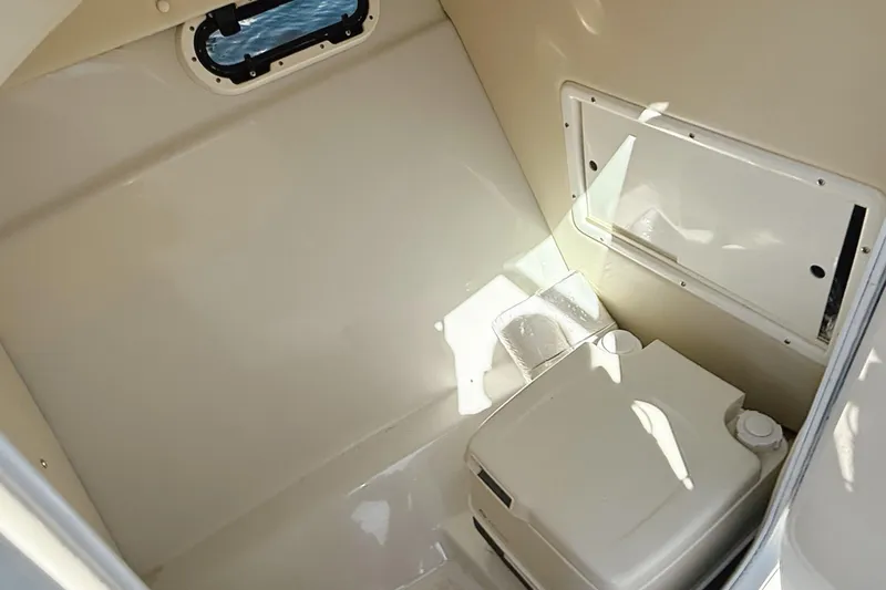 Slide: The Image of Interior of 2000 Four Winns 260 Horizon boat, featuring a compact marine toilet. - 28