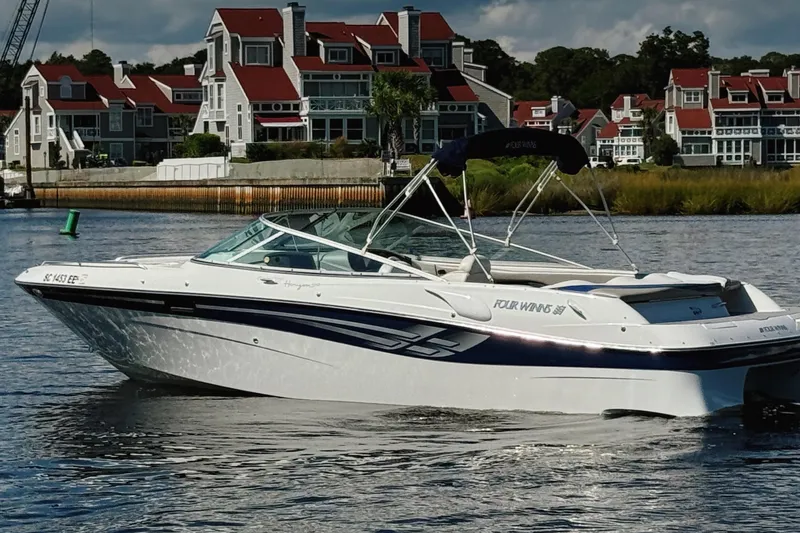 Slide: The Image of 2000 Four Winns 260 Horizon boat on water, with scenic waterfront homes in the background. - 3