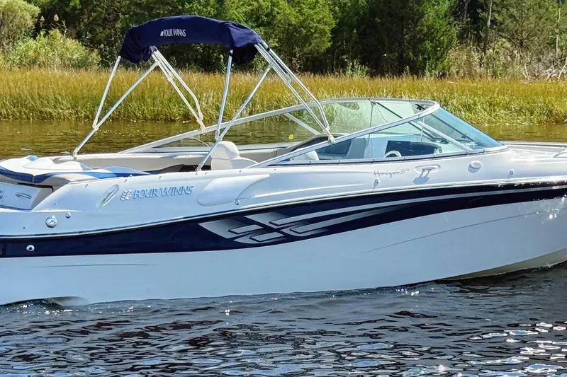 Slide: The Image of 2000 Four Winns 260 Horizon boat on water, featuring sleek design and canopy. - 4