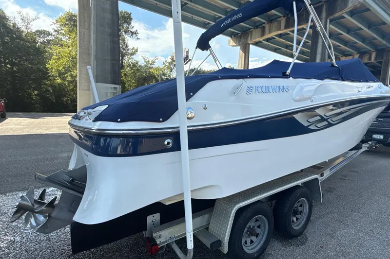 Slide: The Image of 2000 Four Winns 260 Horizon boat on trailer under bridge, covered with blue tarp. - 5