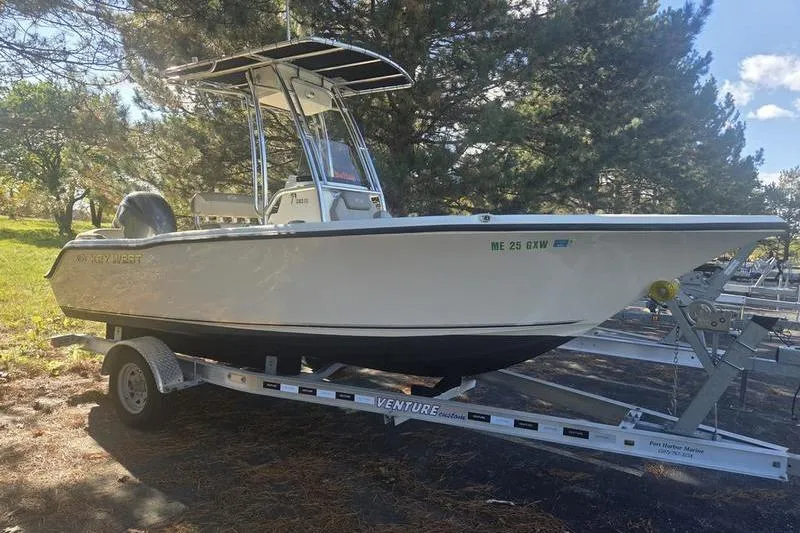 The Image of 2023 Key West 203 FS boat on trailer, parked outdoors under trees. - 2