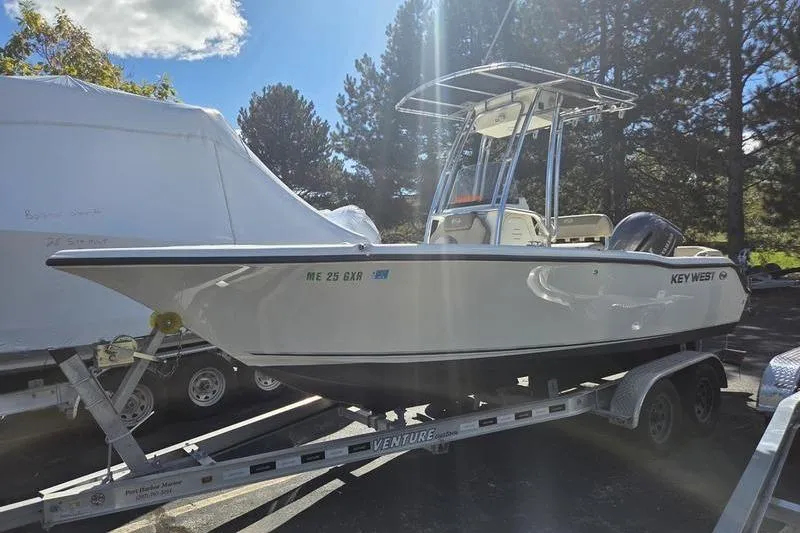 Slide: The Image of 2023 Key West 203 FS boat on trailer, parked outdoors under sunlight. - 10