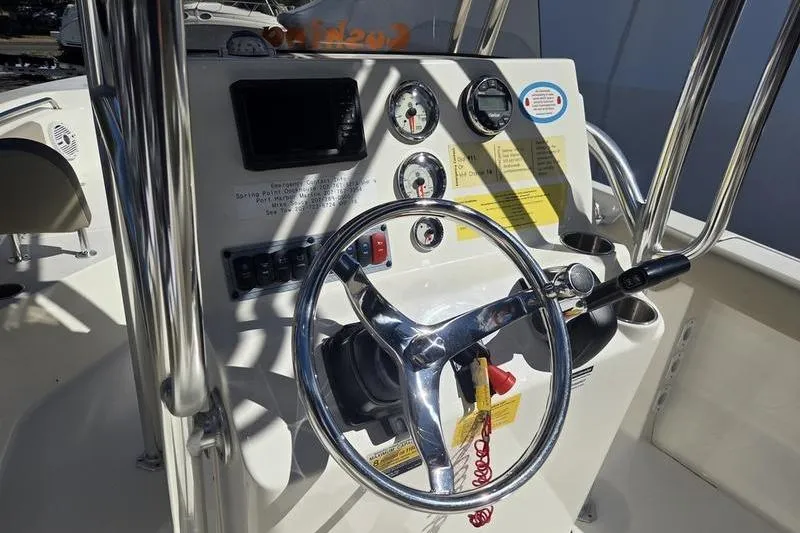 Slide: The Image of 2023 Key West 203 FS boat dashboard with steering wheel and gauges. - 14