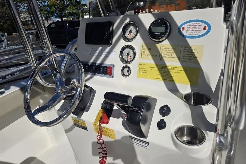 Slide: The Image of 2023 Key West 203 FS boat dashboard with steering wheel, gauges, and controls. - 17
