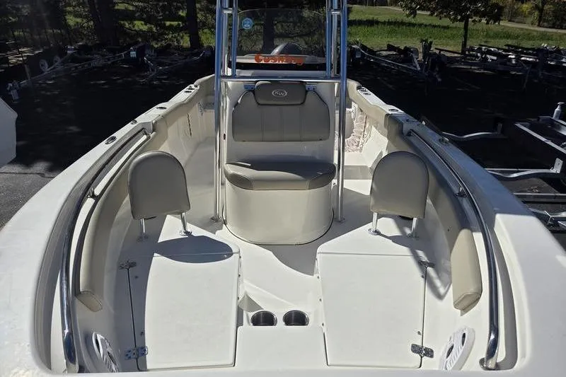 Slide: The Image of 2023 Key West 203 FS boat interior with seating and console, parked outdoors. - 9