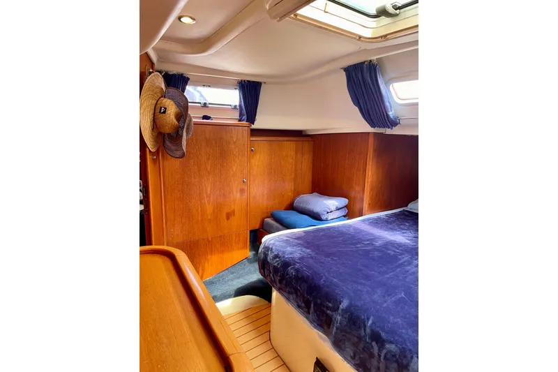 Slide: The Image of Cozy cabin interior of 2000 Moody 42 CC yacht with wooden finish and blue bedding. - 10