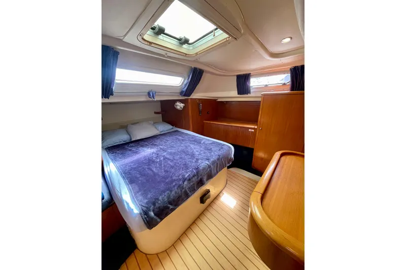 Slide: The Image of Cozy cabin interior of 2000 Moody 42 CC yacht with plush bedding and wooden furnishings. - 11