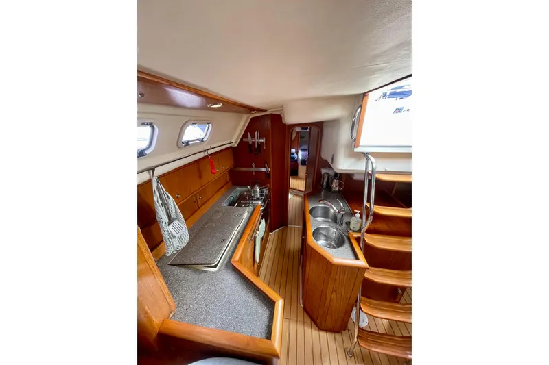 Slide: The Image of Interior of 2000 Moody 42 CC yacht with wooden cabinetry and compact kitchen area. - 32