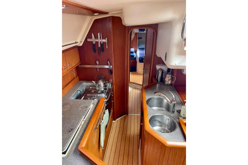 Slide: The Image of Moody 42 CC 2000 yacht interior kitchen with wooden cabinetry and dual sinks. - 33