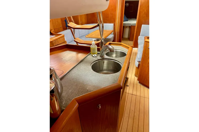 Slide: The Image of Interior of 2000 Moody 42 CC yacht featuring a wooden kitchen with dual sinks. - 34