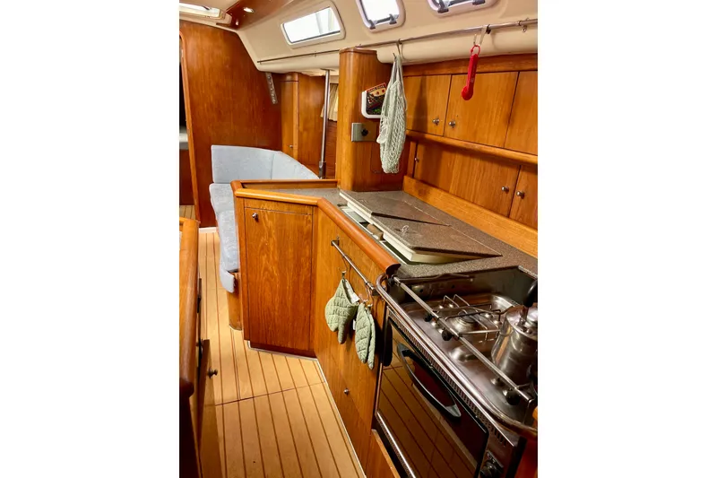 Slide: The Image of Interior of 2000 Moody 42 CC yacht with wooden cabinetry and compact kitchen area. - 35