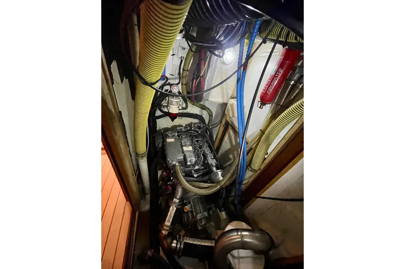 Slide: The Image of Engine room of a 2000 Moody 42 CC sailboat with visible hoses and equipment. - 44