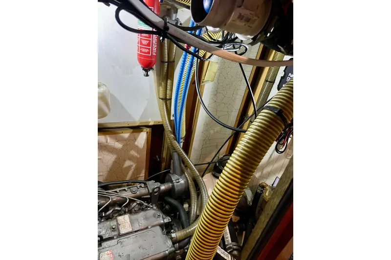 Slide: The Image of Engine room of a 2000 Moody 42 CC sailboat with hoses and fire extinguisher. - 46