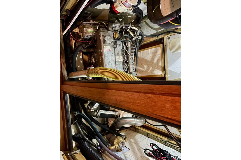 Slide: The Image of Engine compartment of a 2000 Moody 42 CC sailboat, showcasing mechanical components and wiring. - 47