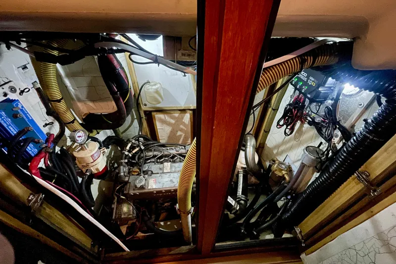Slide: The Image of Engine room of a 2000 Moody 42 CC sailboat, featuring complex wiring and components. - 48