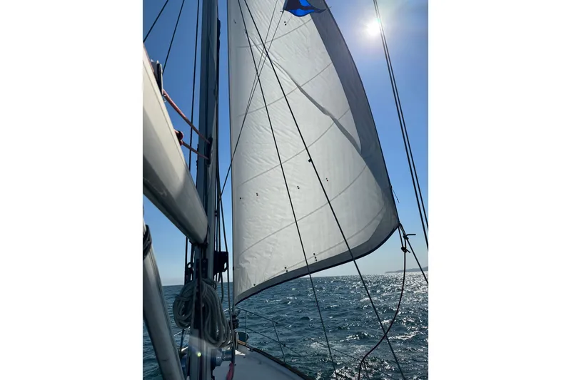 Slide: The Image of Sailing on a 2000 Moody 42 CC yacht with sunlit sails and ocean view. - 79
