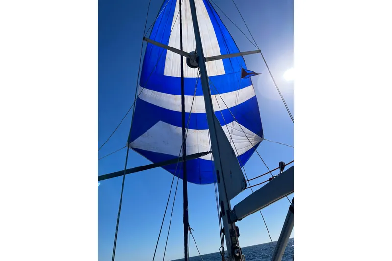 Slide: The Image of Sailboat with blue and white spinnaker, Moody 42 CC, 2000 model, under clear sky. - 80