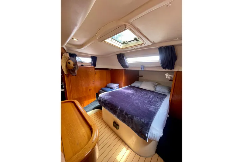 Slide: The Image of Cozy cabin interior of 2000 Moody 42 CC yacht with double bed and wooden accents. - 9