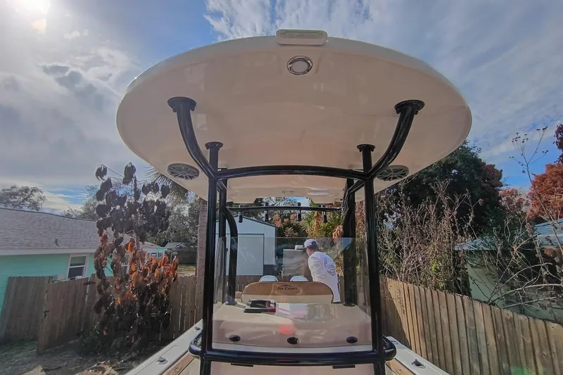 Slide: The Image of 2024 Sea Chaser 24 HFC boat with T-top, parked outdoors under a sunny sky. - 16