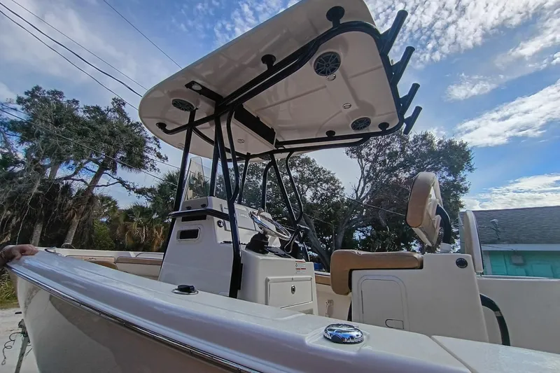 Slide: The Image of 2024 Sea Chaser 24 HFC boat with T-top and console, under a partly cloudy sky. - 20