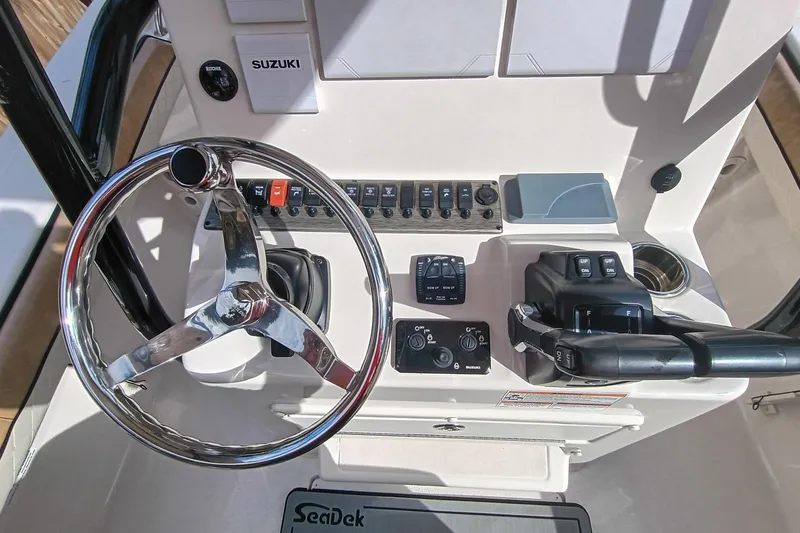Slide: The Image of 2024 Sea Chaser 24 HFC boat dashboard with steering wheel and controls. - 24