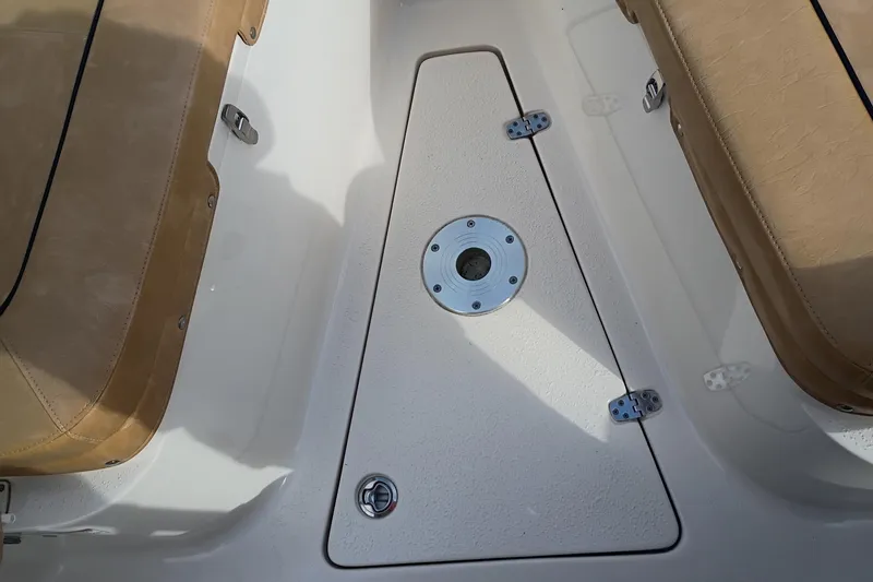 Slide: The Image of 2024 Sea Chaser 24 HFC boat interior with tan seating and storage compartment. - 26