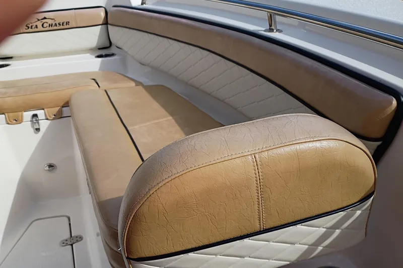 Slide: The Image of 2024 Sea Chaser 24 HFC boat interior with tan leather seating and logo. - 27