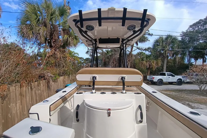 Slide: The Image of 2024 Sea Chaser 24 HFC boat interior with seating and console, surrounded by palm trees. - 35