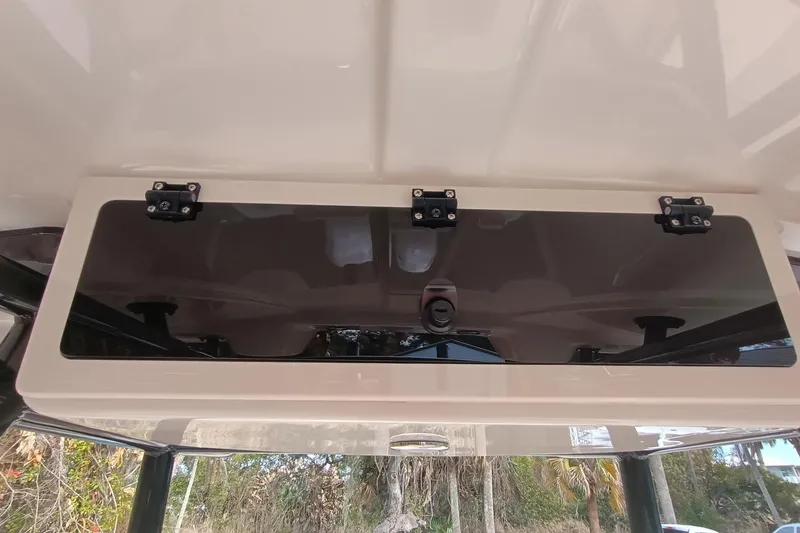 Slide: The Image of 2024 Sea Chaser 24 HFC boat interior with tan and white seating, speaker, and storage. - 39