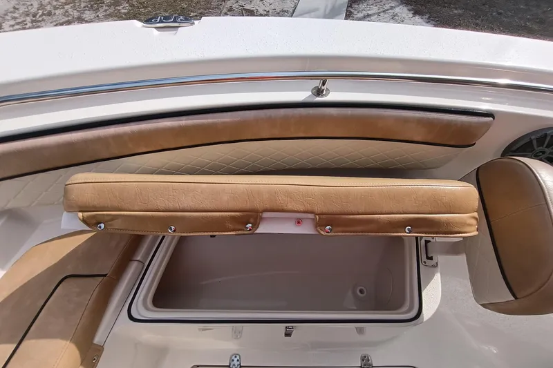 Slide: The Image of 2024 Sea Chaser 24 HFC boat interior with tan cushioned seating and storage compartment. - 44
