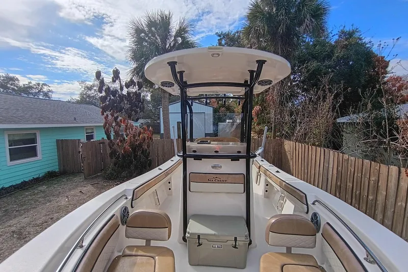 Slide: The Image of 2024 Sea Chaser 24 HFC boat with T-top and seating, parked in a backyard. - 51