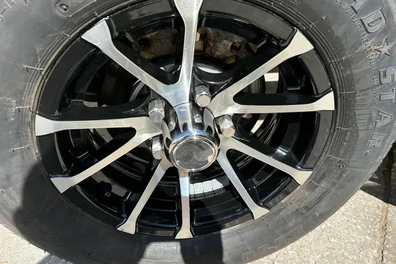 Slide: The Image of 2024 Sea Chaser 24 HFC boat on trailer, parked outdoors under a partly cloudy sky. - 6