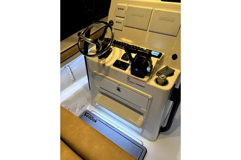 Slide: The Image of 2024 Sea Chaser 24 HFC boat console with blue LED lighting and steering wheel. - 61