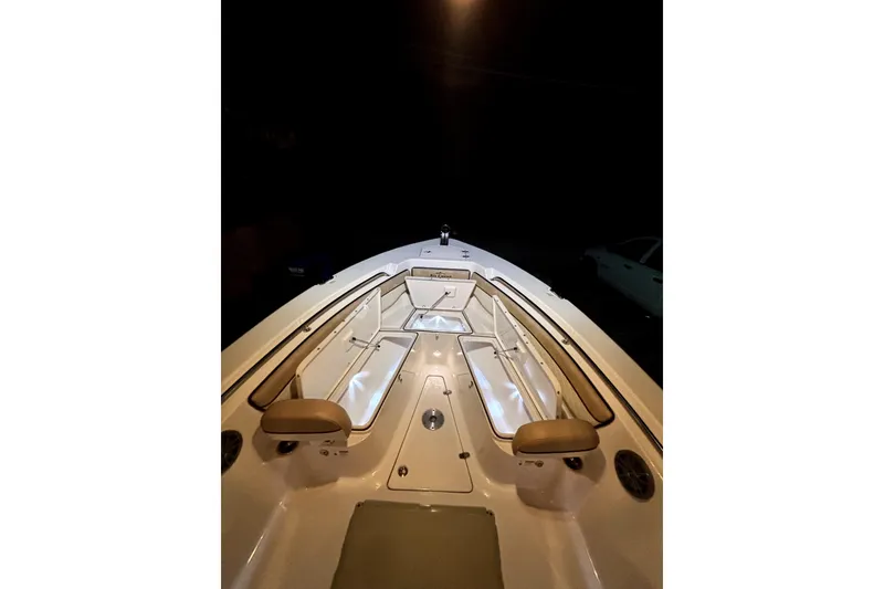 Slide: The Image of 2024 Sea Chaser 24 HFC boat illuminated at night with blue lights. - 65