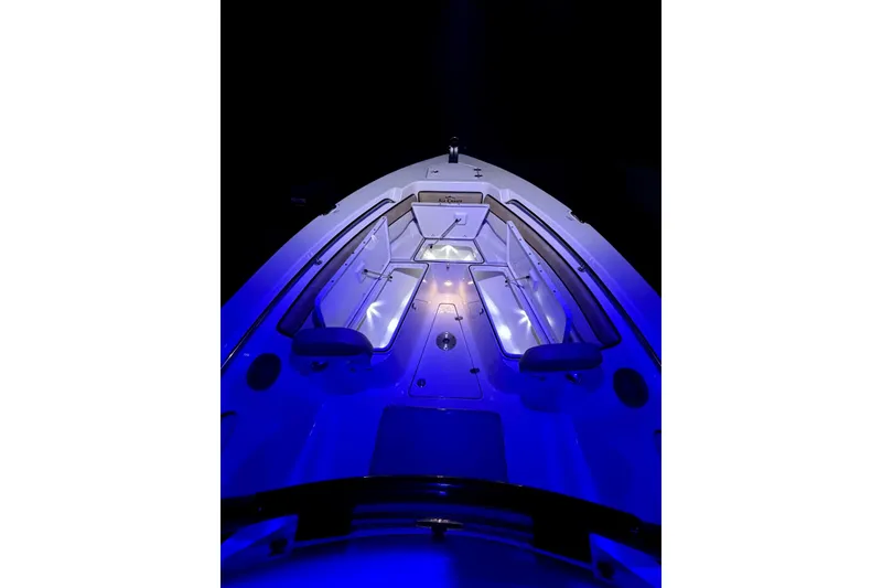 Slide: The Image of 2024 Sea Chaser 24 HFC boat illuminated at night with blue lights. - 67