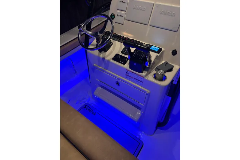 Slide: The Image of 2024 Sea Chaser 24 HFC boat interior at night, showcasing seating and storage. - 72