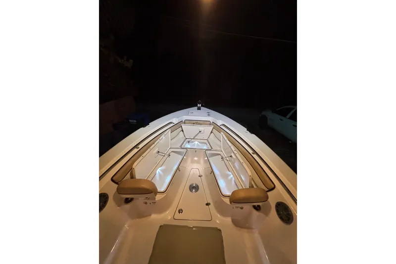 Slide: The Image of 2024 Sea Chaser 24 HFC boat illuminated with colorful lights at night. - 74