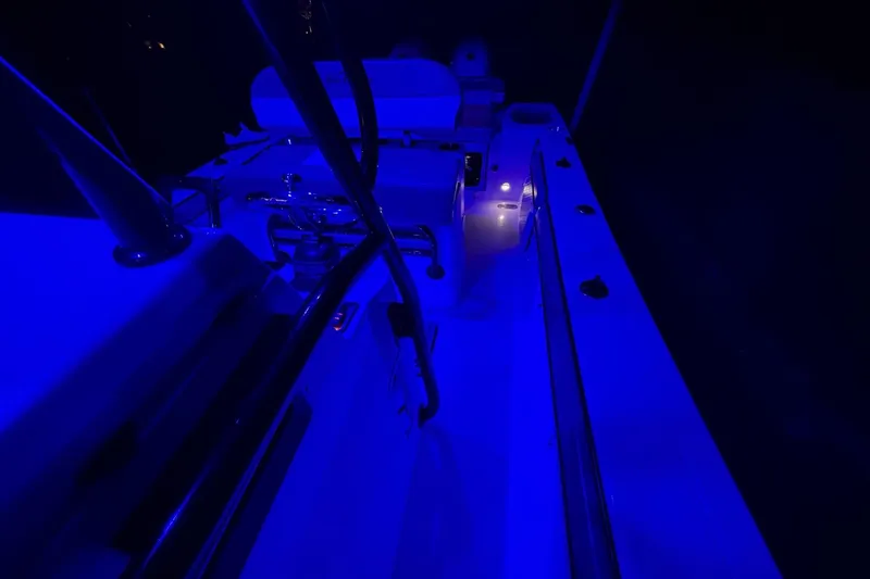 Slide: The Image of 2024 Sea Chaser 24 HFC boat interior illuminated with blue lighting at night. - 77