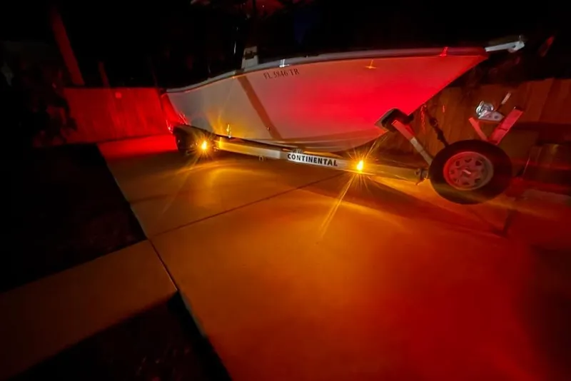 Slide: The Image of 2024 Sea Chaser 24 HFC boat on trailer, illuminated by red lights at night. - 81